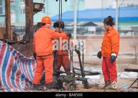 Lavoratori di olio la perforazione di un nuovo pozzo petrolifero di Daqing campo petrolifero nel nord della Cina Foto Stock