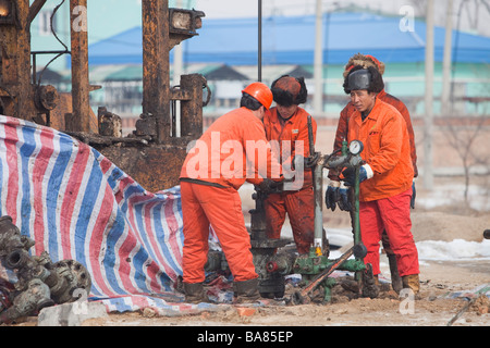 Lavoratori di olio la perforazione di un nuovo pozzo petrolifero di Daqing campo petrolifero nel nord della Cina Foto Stock