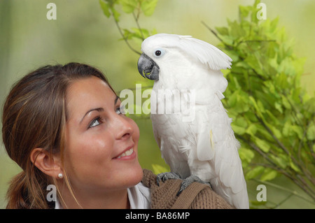 Donna con ombrello Cacatua sulla spalla / Cacatua alba Foto Stock