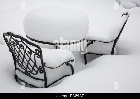 Coperte di neve tavolo e sedie su un patio in seguito ad un inverno severo tempesta di neve. Foto Stock