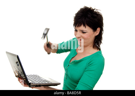 Donna di colpire un computer portatile con un martello Foto Stock