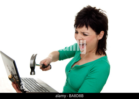 Donna di colpire un computer portatile con un martello Foto Stock