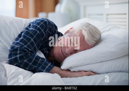 Senior uomo dorme nel letto Foto Stock