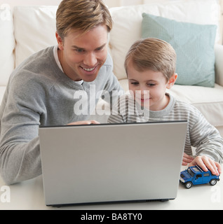 Padre e figlio guardando al laptop Foto Stock