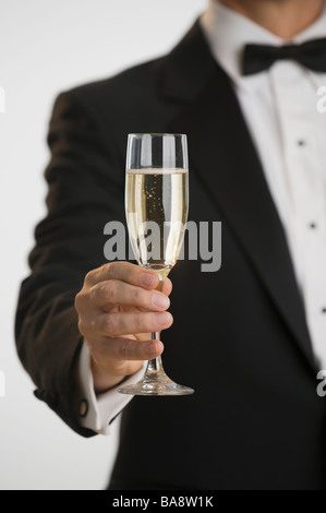 Uomo in smoking tostare con champagne Foto Stock