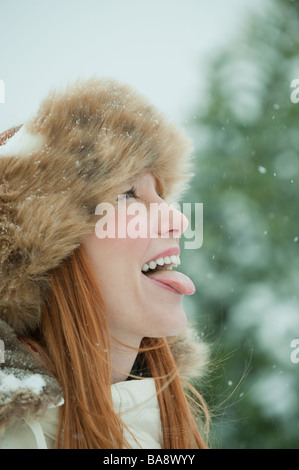 La donna la cattura di neve sulla linguetta Foto Stock