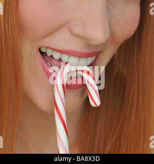 Donna di mordere candy cane Foto Stock