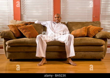 Ritratto di nudi African American uomo seduto sul divano Foto Stock