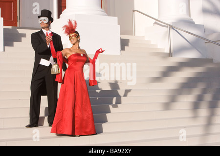 Matura in costumi masquerade in piedi al di fuori del teatro Foto Stock