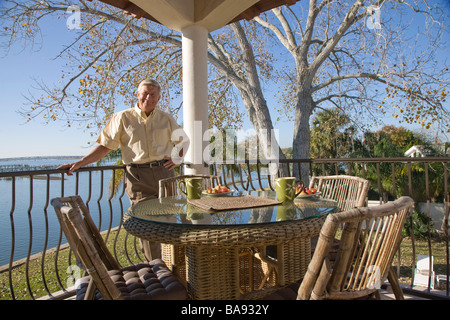 Ritratto di senior uomo in piedi sulla veranda della casa Foto Stock