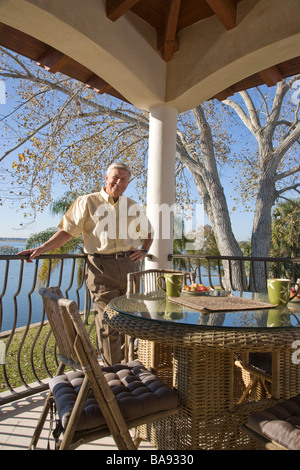 Ritratto di senior uomo in piedi sulla veranda della casa Foto Stock