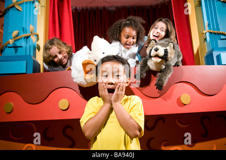 Scuola asiatica boy urlando con i compagni di classe e insegnante nel teatro dei pupi Foto Stock