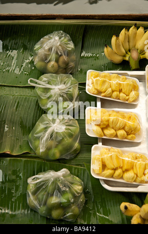 Limes & frutta Durian pronti per la vendita su una barca al mercato galleggiante vicino a Bangkok in Tailandia Foto Stock