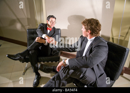 Multi-razziale imprenditori stringono le mani in un ufficio moderno lobby Foto Stock