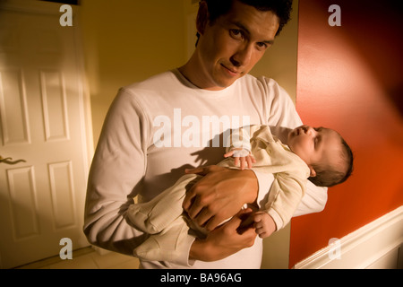 Padre holding baby boy a casa Foto Stock