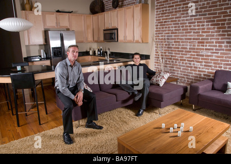 Giovani uomini adulti seduti nel centro moderno loft Foto Stock