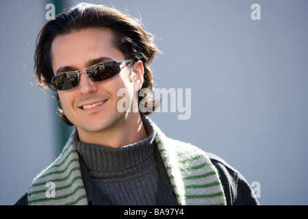 Giovane uomo in occhiali da sole sorridente Foto Stock