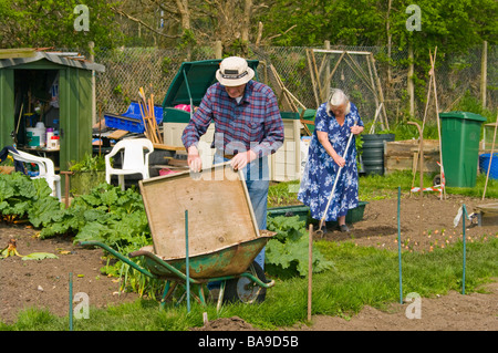 Coppia anziana coppia di lavoro di giardinaggio sul loro giardino riparto Foto Stock