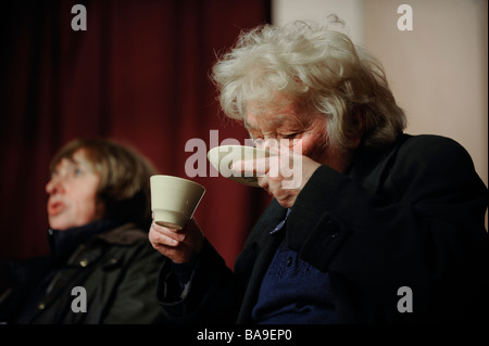 Una donna a cuor leggero bere il tè da piattino. Foto da Jim Holden. Foto Stock