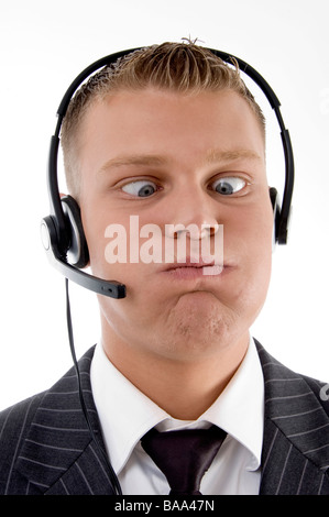 Giovane uomo tira un divertente volto con occhi squinted Foto Stock