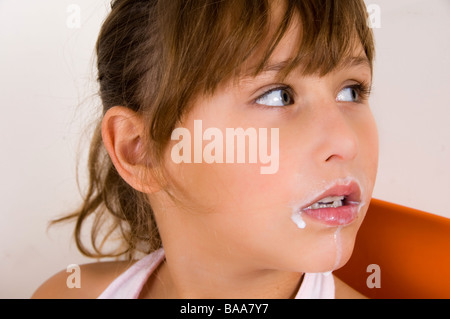 Bambina con baffi di latte Foto Stock