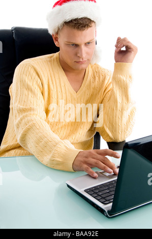 L'uomo con il cappello da Babbo Natale e di lavoro sul computer portatile Foto Stock