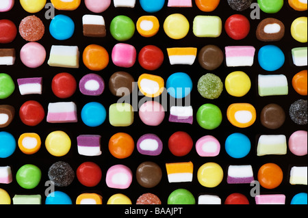 Multicolore miscele dolly e smarties dolci pattern su nero Foto Stock