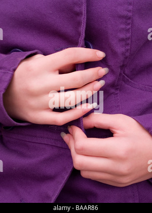 Ragazze mani abbottonatura cappotto Foto Stock