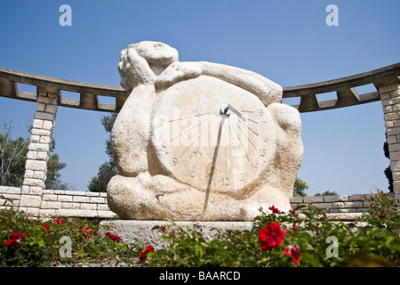 L'orologio solare a Ramat Hanadiv, Zichron Yaakov, Israele con una rosa rossa in primo piano. Foto Stock