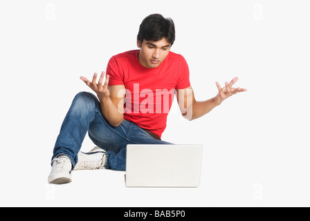 L'uomo gesticolando davanti a un computer portatile Foto Stock