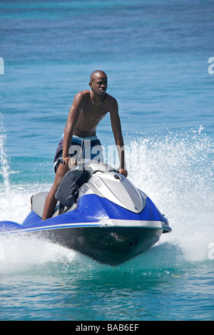 Local Bajan uomo a cavallo su un 'Jet Ski' o acqua Personal Craft (PWC) nella West Coast di Barbados, 'West Indies' Foto Stock