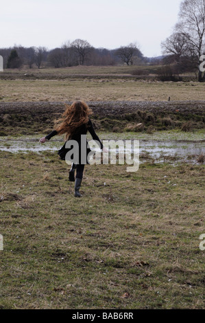 Una giovane donna in esecuzione su un campo in Svezia. Foto Stock