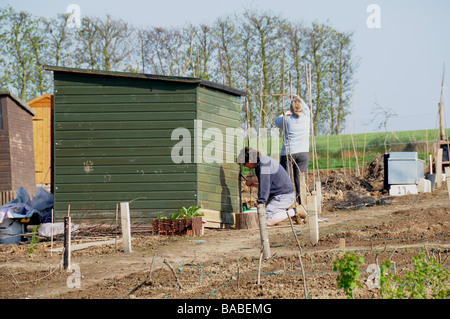 Nuovo riparto locatari a Greenway frutticolo, Herstmonceux, East Sussex, pittura loro versato sulla loro plot. Foto Stock