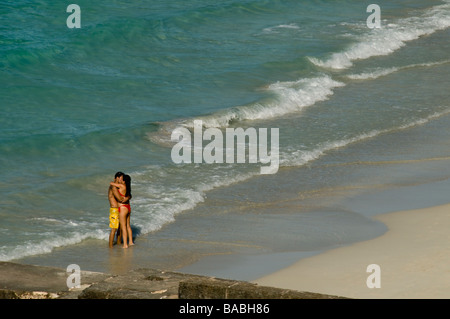 Coppia giovane abbracciando e baciando su una spiaggia incontaminata di Cuba Foto Stock