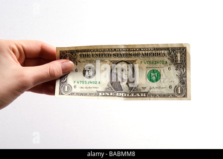 Donna di mano che tiene una banconota del dollaro contro uno sfondo bianco Foto Stock