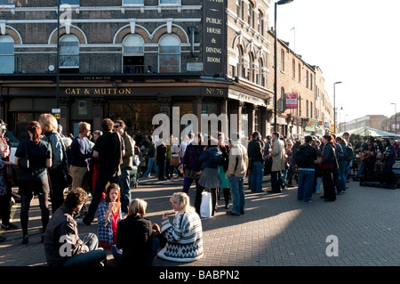 I giovani di bere al di fuori il gatto e il montone pub sull'angolo di Broadway Market, Hackney, Londra, Regno Unito Foto Stock