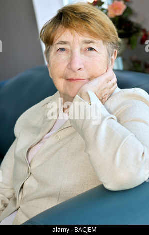 Donna anziana seduta in bianco lino camicia Foto Stock