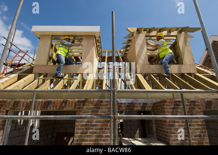 Carpentieri di lavoro sul tetto di una casa nuova. Foto Stock