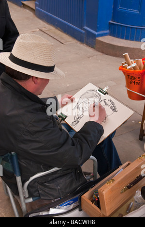 Una caricatura artista al lavoro su una delle sue caricature di York,Yorkshire, Regno Unito Foto Stock