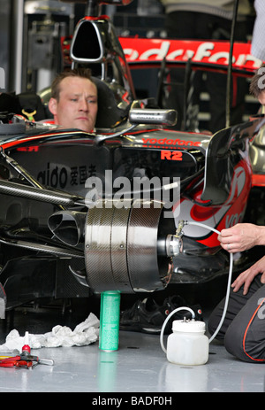 Vodafone McLaren Mercedes meccanici ai box lavorando su Lewis Hamilton della vettura. Foto Stock