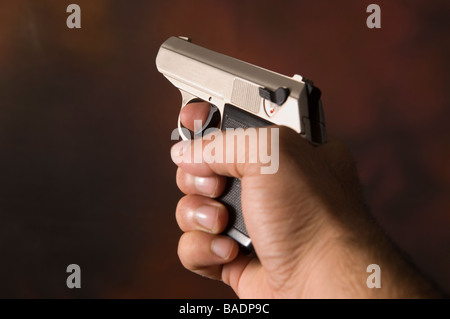 Mano d'uomo in possesso di una pistola tiro Foto Stock