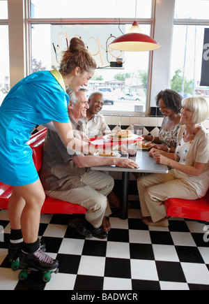 Cameriera serve clienti in retrò Diner Foto Stock