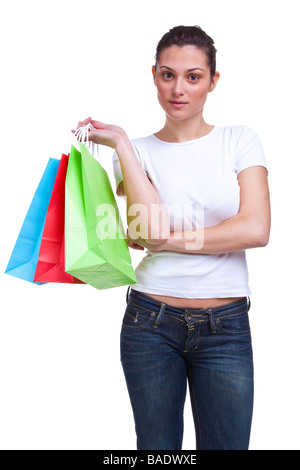 Un attraente giovane donna attende le braccia incrociate con coloratissime shopping bags isolato su uno sfondo bianco Foto Stock