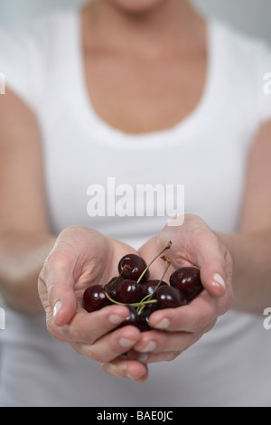 Donna che mantiene le ciliegie Foto Stock