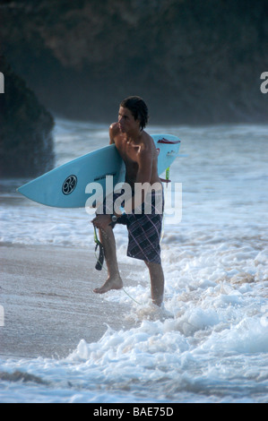 Un surfista si allenta la sua fascetta di surf dopo provenienti dal mare