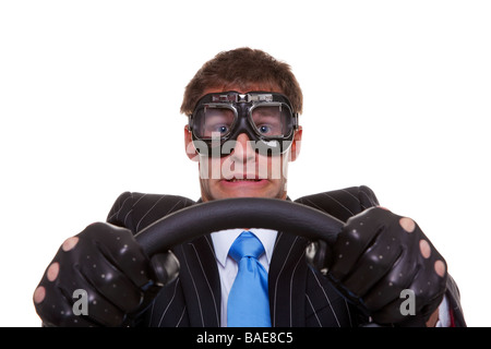 Businessman in driving gloves and goggles with a look of panic on his face isolated on white background Foto Stock
