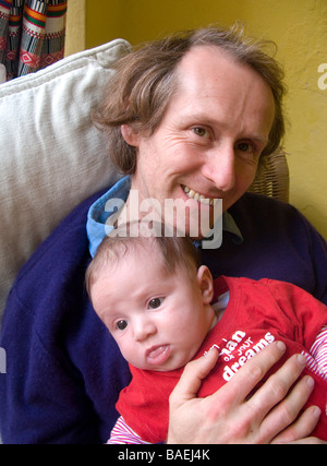 Uomo seduto tenendo baby Foto Stock