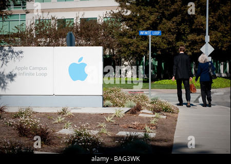 Sign in il font del quartier generale della Apple Computer Inc. con due lavoratori a piedi passato. Foto Stock