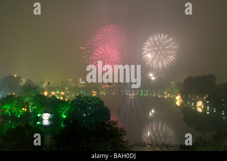 Fuochi d'artificio su un fumoso Lago Hoan Kiem per Tet festeggiamenti in Hanoi Vietnam Foto Stock