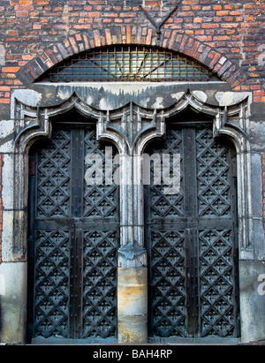 Vecchia porta medievale realizzata in pietra e legno. Parte della storica cattedrale con pareti in mattoni. Foto Stock